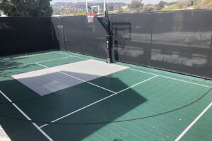 Cushioned tile basketball court with catch fence